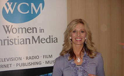 Wendie Pett smiling in front of a Women in Christian Media banner to represent how to Get Visibly Fit™ in body, mind and spirit .