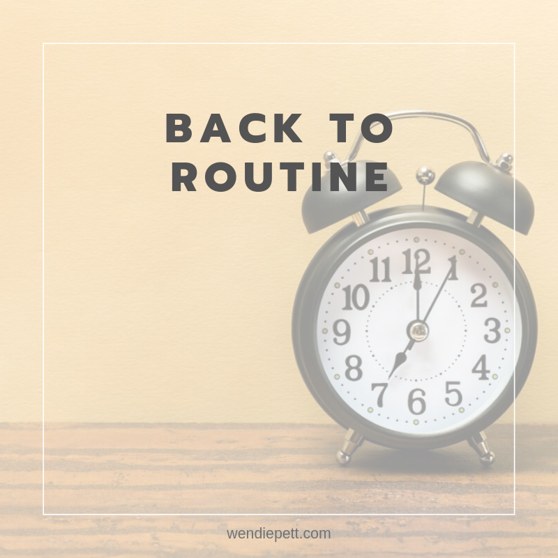 Photo of a traditional alarm clock and text that reads, "back to routine".