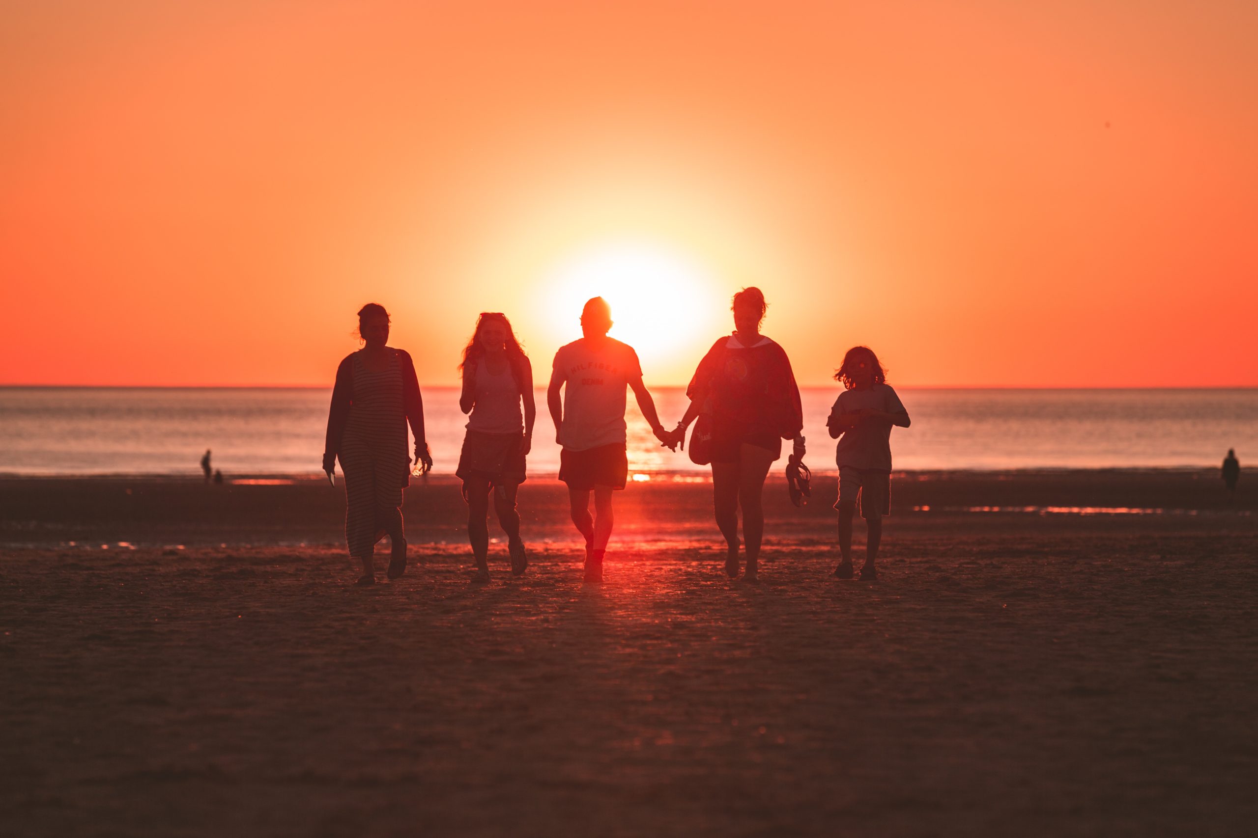 Family walking together on a beach at sunset